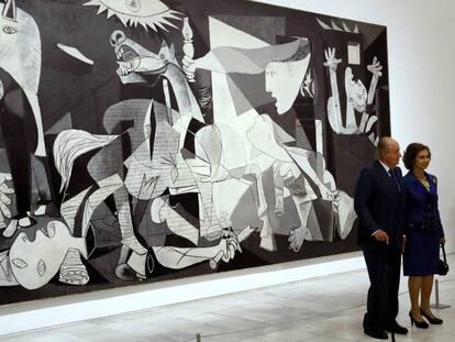 Los reyes Juan Carlos y Sofía posan ante el 'Guernica' de Picasso en la exposición por su 80 aniversario.