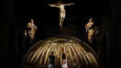 Dos personas contemplan la venera de la cúpula del retablo mayor de San Benito el Real, obra de Alonso Berruguete, este martes en Valladolid.