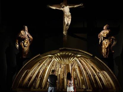 Dos personas contemplan la venera de la cúpula del retablo mayor de San Benito el Real, obra de Alonso Berruguete, este martes en Valladolid.