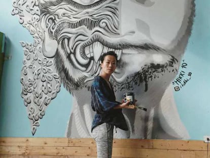 La artista Luanna Lee, junto a una de sus creaciones en un albergue en Bangkok (Tailandia), en la pasada primavera.