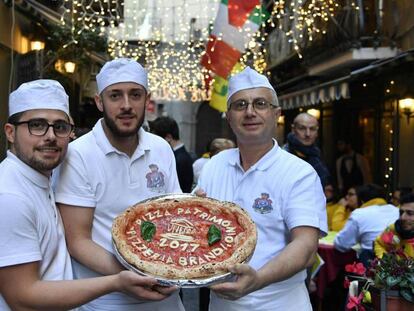 Tres 'pizzaioli' posan en Nápoles con una pizza, para celebrar su inclusión en el Patrimonio Inmaterial de la Unesco.