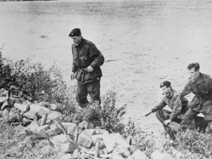 Cuatro paracaidistas británicos atraviesan un río.
