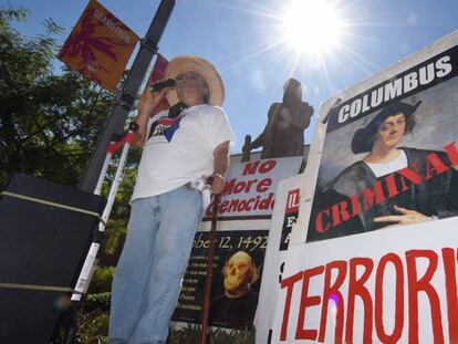 El activista Olin Tezcatlipoca frente a la estatua de Cristobal Colón en el Grand Park, de Los Ángeles, en 2015. En vídeo, la retirada de la estatua la semana pasada.