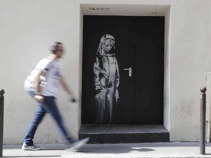 Un hombre cruza, el pasado mes de julio, por delante de la puerta de emergencia de Bataclan con el 'banksy'.