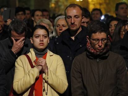 Personas congregadas la noche del lunes ante la catedral rezan mientras esta es devastada por las llamas. En vídeo, el anuncio del presidente Macron.