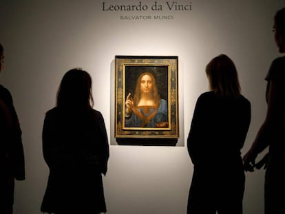 Empleados de Christie's, frente a la obra antes de ser subastada en 2017. En vídeo, el 'Salvator Mundi', el cuadro más caro de la historia, pone en jaque el rigor del Louvre.