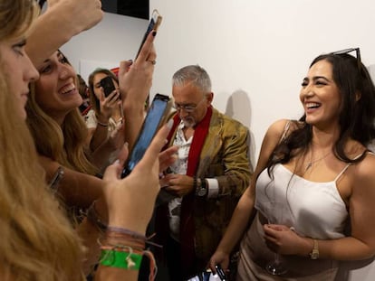 Una visitante es fotografiada frente a la obra 'Comediante', el sábado. En vídeo, el momento en el que un hombre se come el plátano.