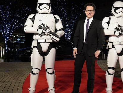 El director J. J. Abrams, con dos soldados imperiales, en un evento de 'Star Wars' en Tokio, el 11 de diciembre. En el vídeo, una secuencia de 'El ascenso de Skywalker'.