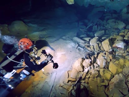Un arqueólogo submarinista, junto a las ánforas romanas halladas en el interior de la cueva de la Fuente de Ses Aiguades en la bahía de Alcudia (Mallorca). En vídeo, el misterio arqueológico de la cueva de Ses Aiguades.