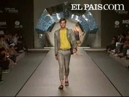 Ana, una de las mitades de los que hace un año eran Locking Shocking, ha presentado hoy una temporada llena de alegría y sofisticación en la que la seda ha sido el tejido protagonista. Para ellas, la diseñadora propone vestidos grises combinados con telas rosas a través de transparencias. El hombre adquiere protagonismo propio en este desfile, en el que se han podido ver trajes de chaqueta combinados con camisas en colores ácidos e incluso un traje de novio masculino que incluye una falda blanca. Las prendas adquieren elegancia a medida que avanza el desfile, con camisas de volantes adornadas con cristales de Swarovski. Para la noche, la diseñadora propone vestidos largos en tonos neutros que dejan entrever la silueta de la mujer.