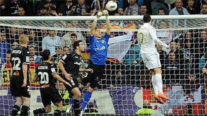 Cristiano Ronaldo salta ante el portero del Valencia, Guaita.