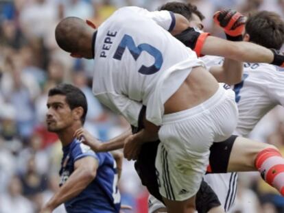 Casillas choca con Pepe en su intento por despejar.