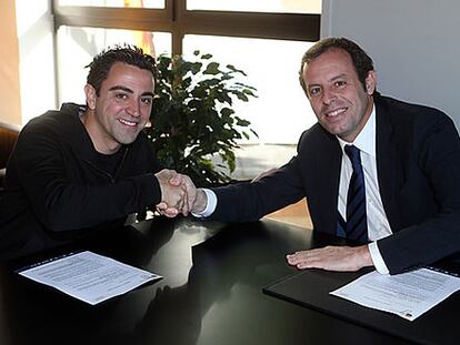 Xavi y Rosell se estrechan la mano durante el acto.