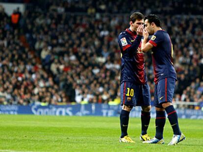 Messi y Xavi se disponen a ejecutar un lanzamiento de falta.