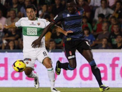 Nyom pelea un balón con Mantecón, del Elche.