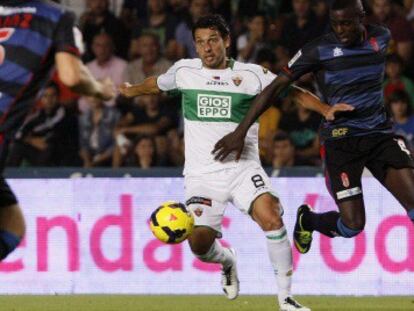 Nyom pelea un balón con Mantecón, del Elche.