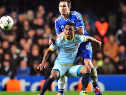 Lampard y Leandro Tatu pelean un balón.