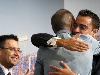 Xavi se abraza a Iniesta ante el presidente Bartomeu.