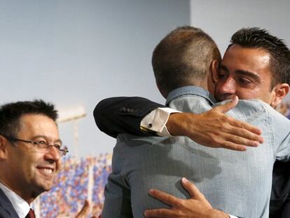 Xavi se abraza a Iniesta ante el presidente Bartomeu.