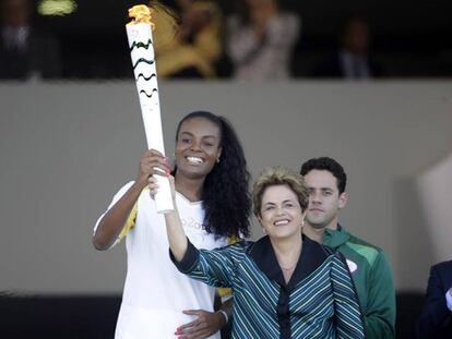 La presidenta Dilma y la atleta Fabiana cogen la antorcha olímpica.