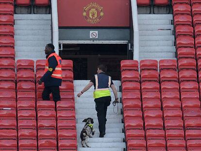 Dos miembros del equipo de seguridad de Old Trafford inspeccionan una de las gradas.