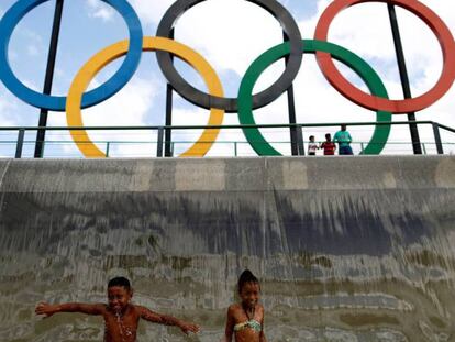 Unos niños juegan en una fuente con los anillos en Río.