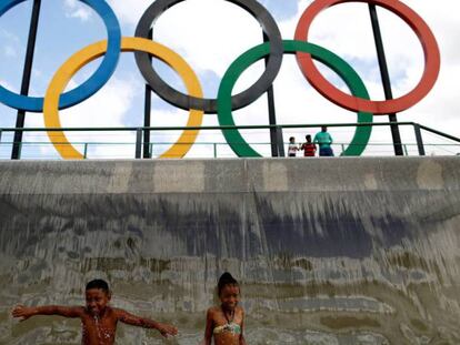 Unos niños juegan en una fuente con los anillos en Río.