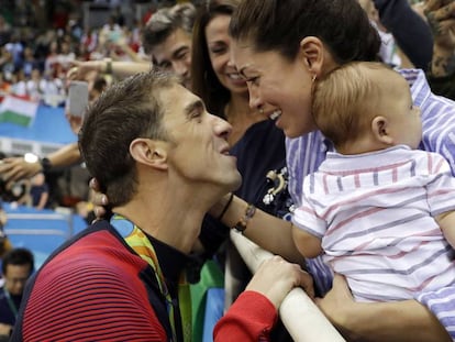 Michael Phelps, a la izquierda, se felicita junto a su novia, Nicole, y su hijo, Boomer, tras ganar los 200m mariposa.