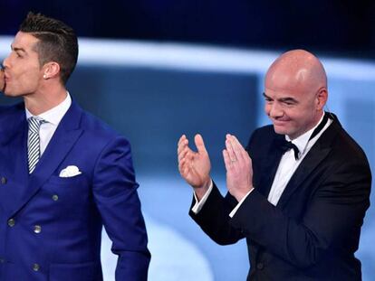 Cristiano Ronaldo beija o troféu de melhor jogador de 2016 sob o olhar de Gianni Infantino, presidente da FIFA.