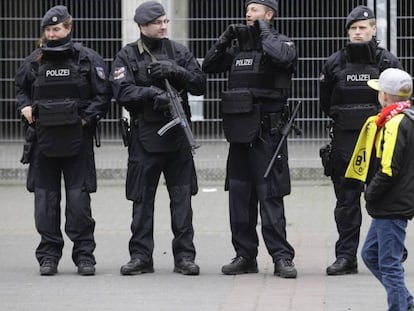 Un niño pasea frente a la policía.