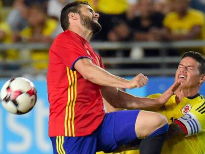 El defensa español Ignacio Fernández pelea el balón con el centrocampista colombiano James Rodríguez.