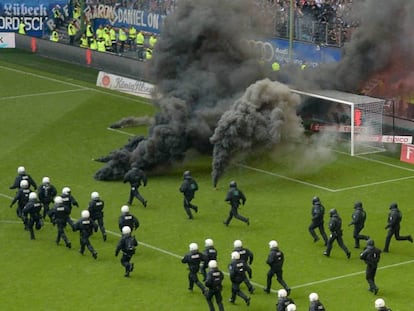 La policía salta al campo después de que ultras del Hamburgo lanzaran este sábado bengalas y botes de humo durante el partido en el que su equipo ha descendido a segunda división.