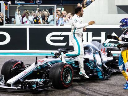 Hamilton acude a saludar a Fernando Alonso tras la victoria del británico en la carrera de ayer en el circuito Yas Marina.