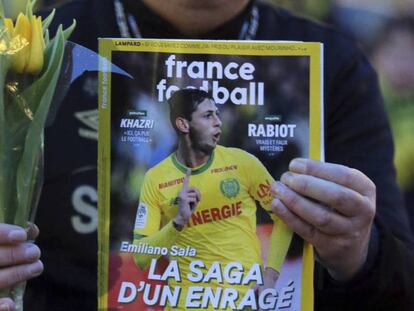 Un seguidor del Nantes sujeta este martes un ramo y una revista de 'France Football' con la imagen de Emiliano Sala. En vídeo, el audio de WhatsApp que Sala envió a sus amigos antes de que se perdiera su rastro.