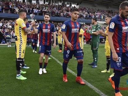 Los jugadores del Nàstic hacen el pasillo a los del Huesca.