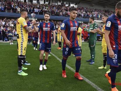 Los jugadores del Nàstic hacen el pasillo a los del Huesca.