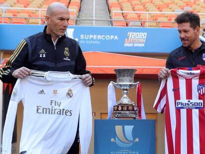 Zinedine Zidane y Diego Simeone posan con las camisetas de sus respectivos equipos tras las ruedas de prensa que han ofrecido este sábado en el estadio King Abdullah.