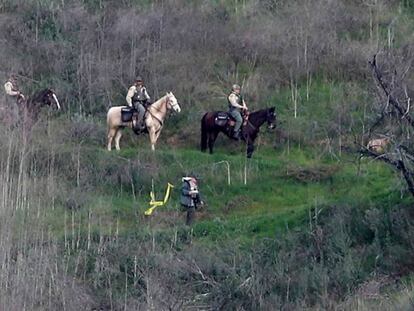 Agentes del 'sheriff' de Los Ángeles patrullan a caballo la colina donde están los restos de la tragedia. En vídeo, las primeras imágenes de los restos del accidente.