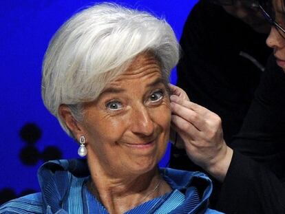 La directora del FMI, sonríe a la cámara mientras le colocan un auricular.