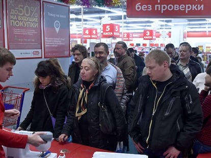 Moscovitas hacen cola frente a la caja de una tienda de electrónica.