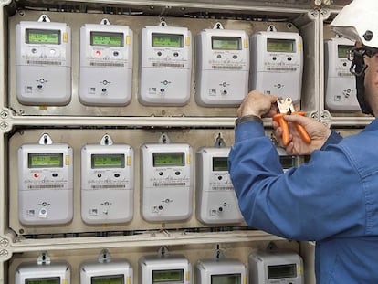 Un operario, colocando contadores eléctricos domésticos inteligentes, en un edificio.