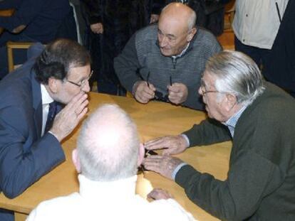 El presidente del Gobierno, Mariano Rajoy, conversa con su pareja de juego en una partida de dominó.