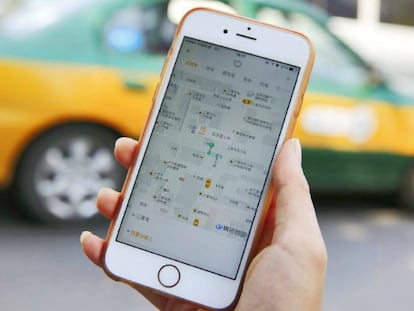 Una mujer muestra en su iPhone la aplicación Didi Chuxing en Pekín (China).