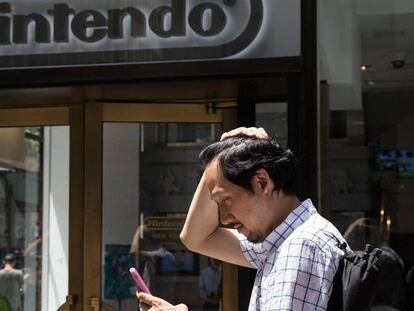 Un hombre juega al Pokemon junto a una tienda de Nintendo en Nueva York