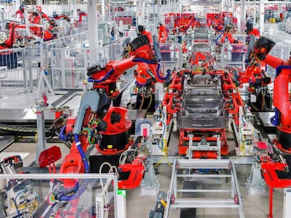 Um linear de robôs montam um carro na planta de Tesla em Fremont