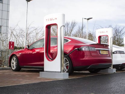 Coches eléctricos de Tesla enchufados a postes de carga.