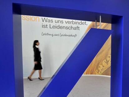 Una mujer pasa delante del logo del banco Deutsche Bank.