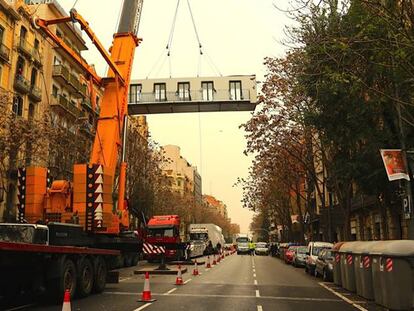 Una grúa coloca el ático de La Casa por el Tejado en la finca de la calle de Aragón, en Barcelona.