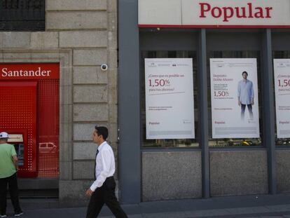 Un hombre pasa frente a una oficina del Popular y otra del Santander.