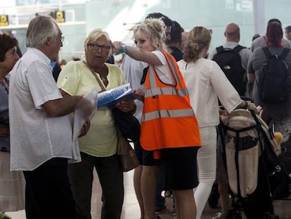 Personal de Aena informa el sábado a los usuarios en los accesos a las puertas de embarque del Aeropuerto de El Prat.